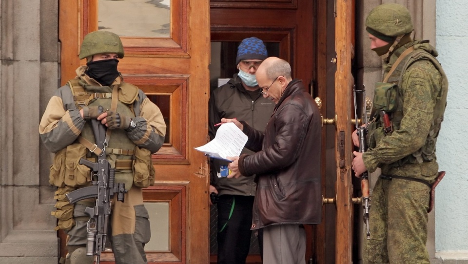 Uzbrojeni mężczyźni w uniformach bez dystynkcji zajęli pozycje w pobliżu gmachu parlamentu w Symferopolu na Krymie. Fot. PAP/EPA