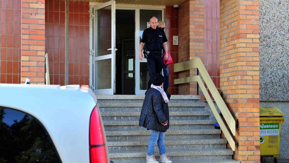 Matka (z tyłu za policjantem) 10-letniej Mai z Wołczkowa wychodzi z komisariatu policji w mieście Friedland w Niemczech, gdzie odnaleziono dziewczynkę. Fot. PAP/Marcin Bielecki