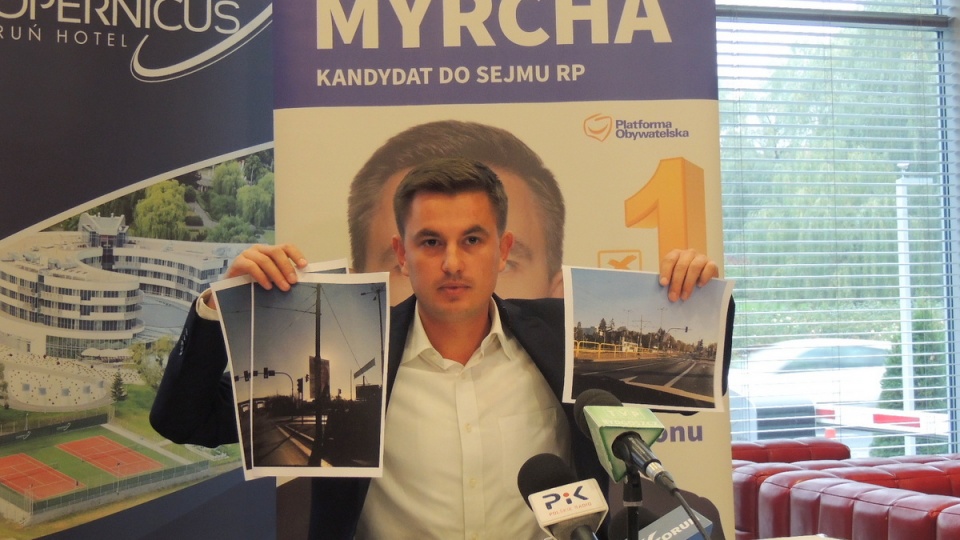 Arkadiusz Myrcha prezentuje zdjęcia dokumentujące nieprawidłowo - jego zdaniem - umieszczone plakaty wyborcze PiS. Fot. Michał Zaręba